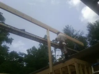 Carpenter setting a ridge beam over a new addition frame — Ice Dam Removal by Roofing Brothers in Encampment